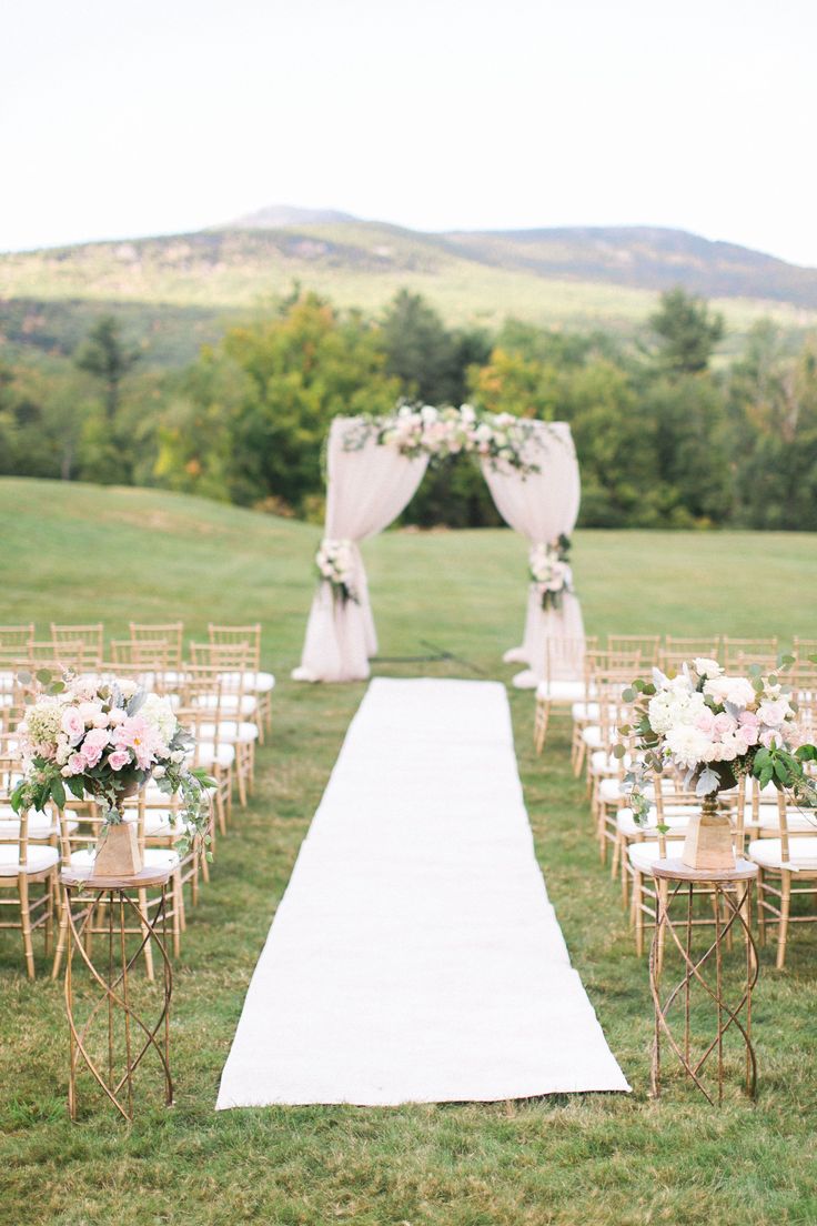 an outdoor ceremony setup with white and pink flowers