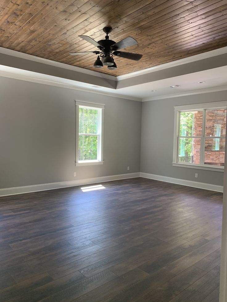 an empty living room with wood floors and ceiling fan