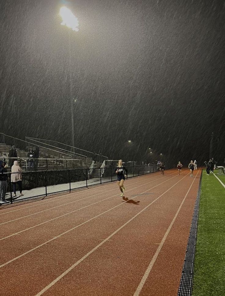 a person running on a track in the rain