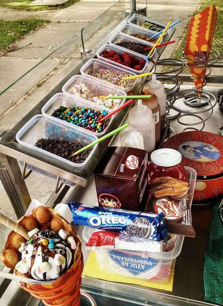 an ice cream sundae is on a table with other desserts and candy bars