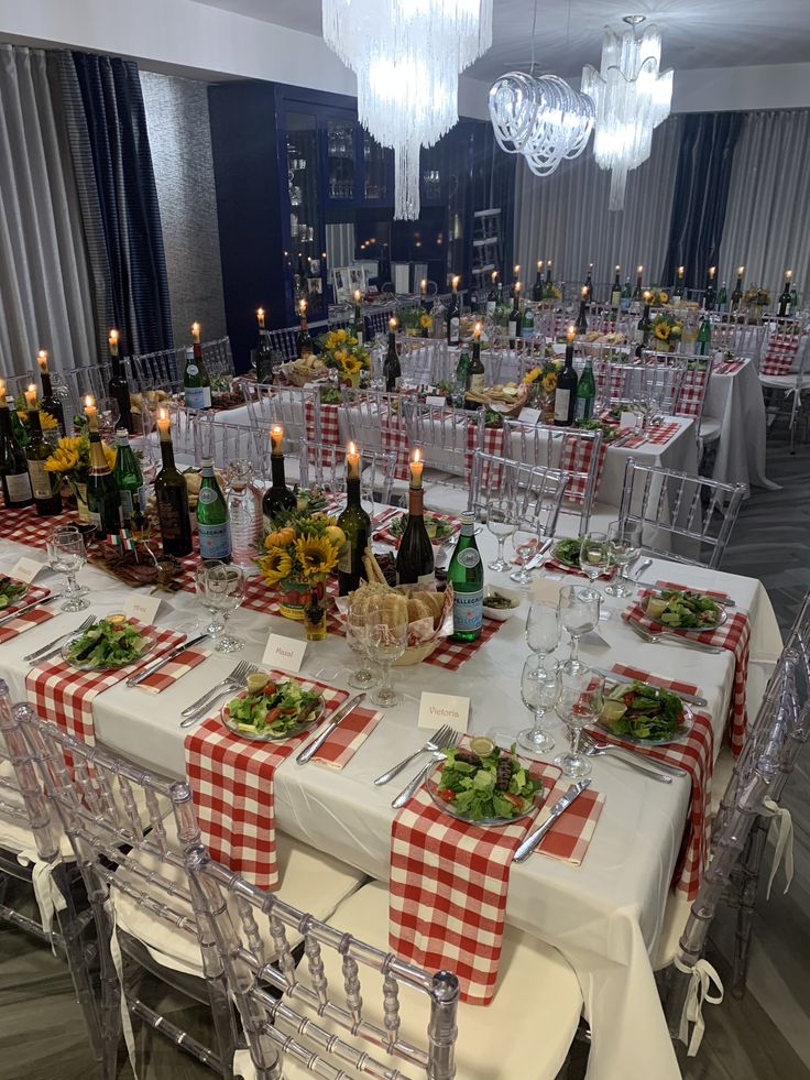 a dining room set up with tables and chairs for an event or gathering, surrounded by candles and wine bottles