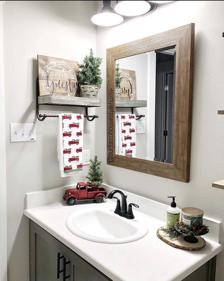 a bathroom with a sink, mirror and christmas decorations on the shelf above the sink