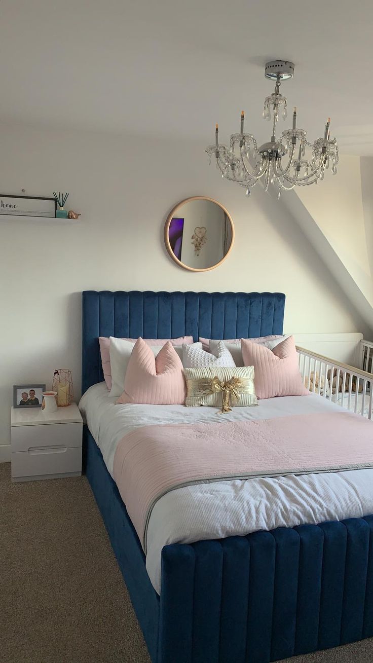 a bedroom with a bed, chandelier and two nightstands in the corner