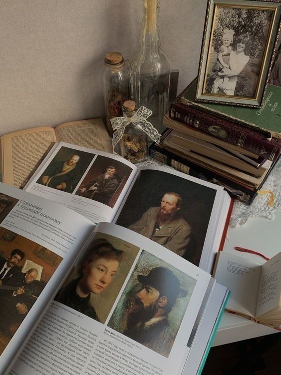 an open book sitting on top of a table next to pictures and bookshelves