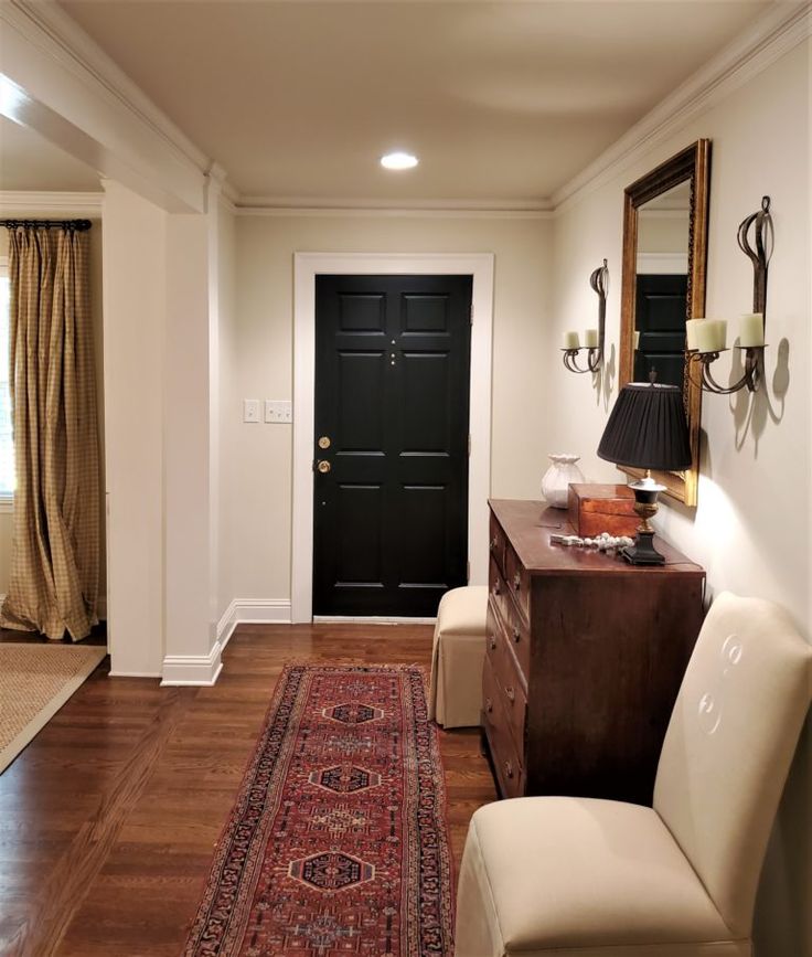 a living room with a black door and white walls