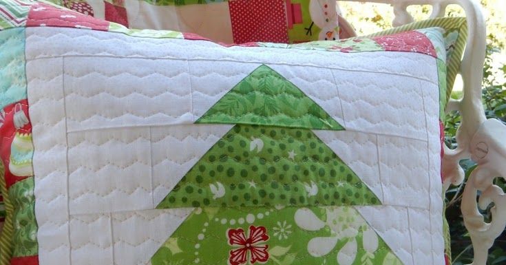 a green christmas tree pillow sitting on top of a white chair