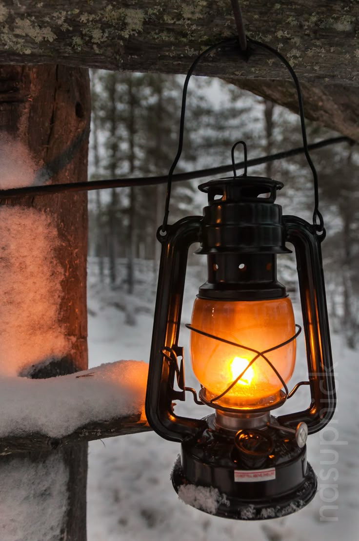 an old fashioned lantern is lit in the snow