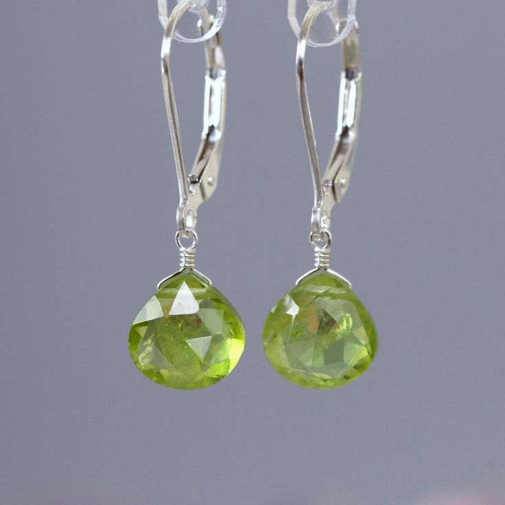 Genuine Peridot Dangle earrings are handcrafted in 14k Gold. MATERIALS: * Solid 14k Gold or 18k Gold * natural peridot * dangling from leverbacks * beautiful branded gift box + card about peridot SIZE: stones: 8x8 mm; earrings: 2.5 cm or 1" MAKE A SET: Matching necklace:  https://etsy.me/2s6lDGN PERIDOT: ∙ August Birthstone ∙ 1st and 16th Wedding Anniversary Gemstone ∙ Talisman for Leo ∙ Heart chakra (Anahata)  Peridot symbolizes inner lightness, safety, and equilibrium. Being a heart chakra sto Green Faceted Round Earrings, Green Round Faceted Earrings, Lime Green Earrings For Gift, Green Briolette Earrings For Wedding, Handmade Peridot Round Earrings, Handmade Round Peridot Earrings, Lime Green Sterling Silver Fine Jewelry, Elegant Lime Green Dangle Earrings, Elegant Lime Green Earrings For Gift