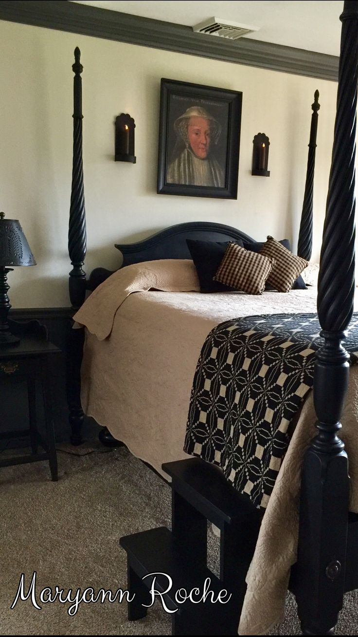 a bedroom with four post bed, nightstands and pictures on the wall above it