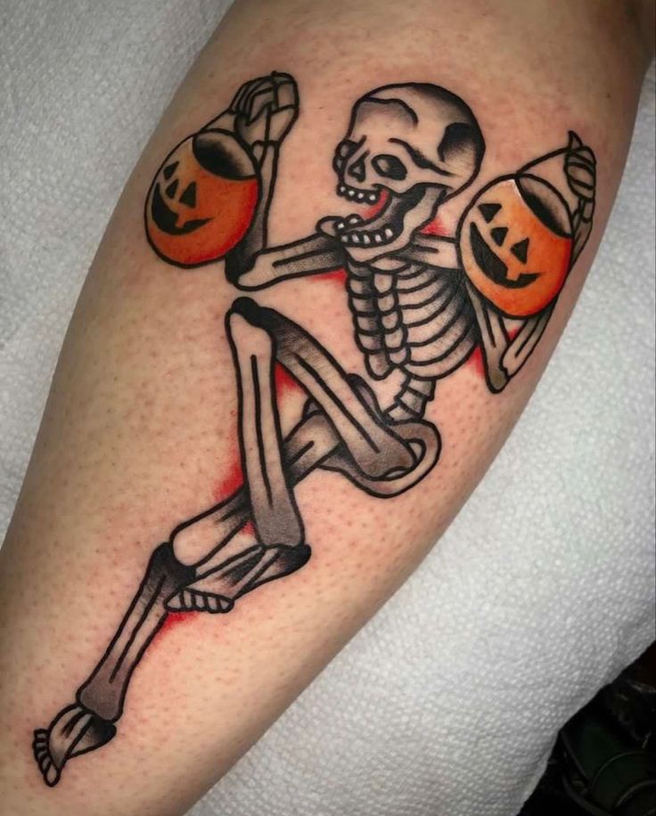 a skeleton holding two pumpkins on his arm