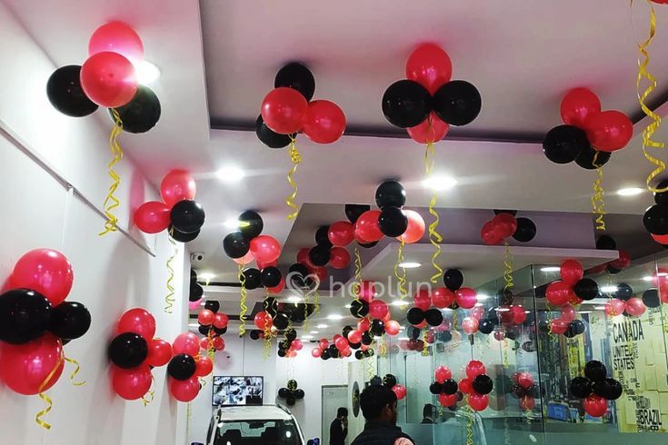 red and black balloons are hanging from the ceiling