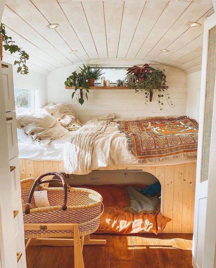 there is a bed in the room with plants on the wall and a basket next to it