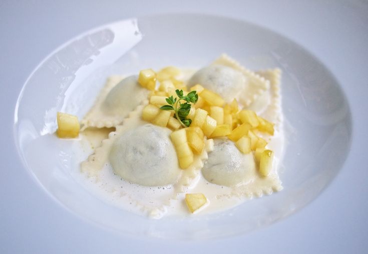 a white plate topped with ravioli and pineapple