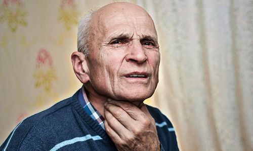 an older man is standing in front of a curtain and looking off into the distance