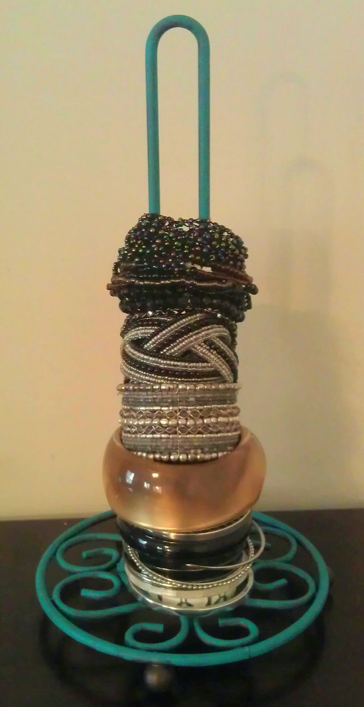 a stack of bracelets sitting on top of a black table next to a white wall