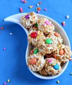 a spoon full of cereal krispy treats on a blue surface with sprinkles