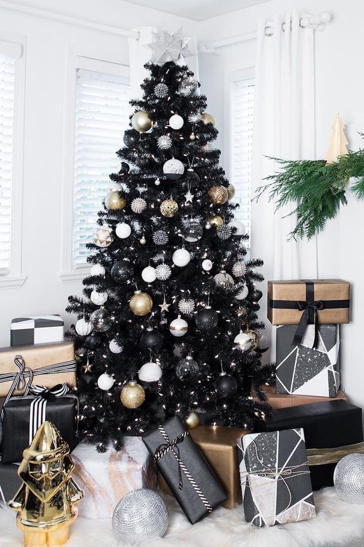 a black and white christmas tree with presents under it, surrounded by other holiday decorations