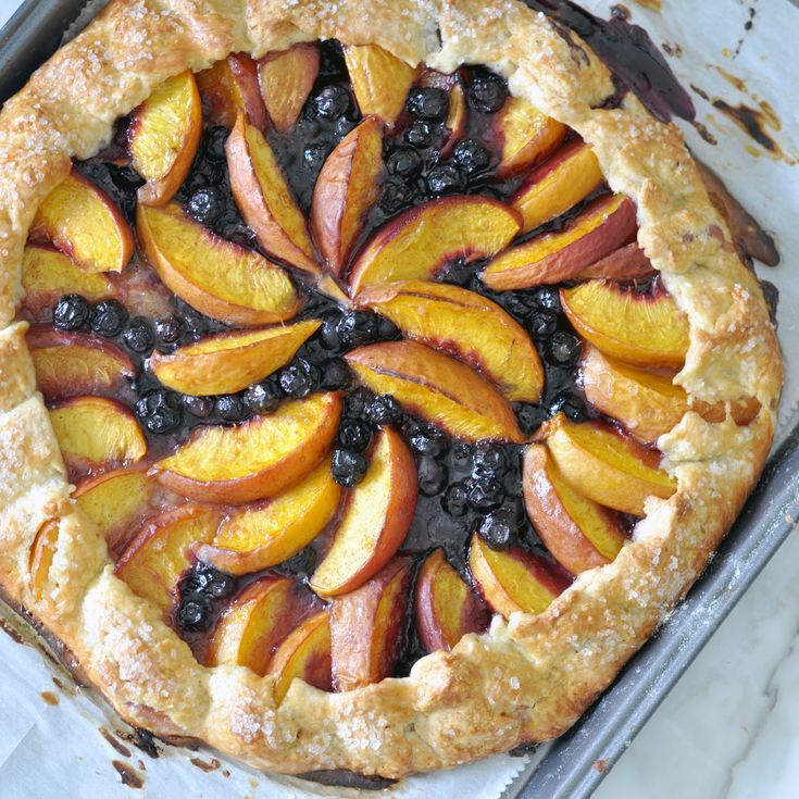 a pie with blueberries and peaches on it