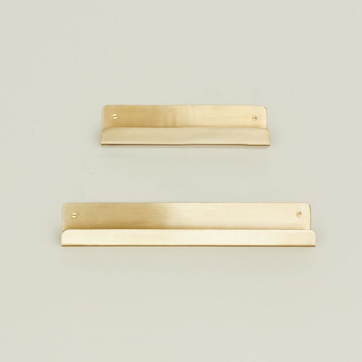 two brass drawer pulls on a white background