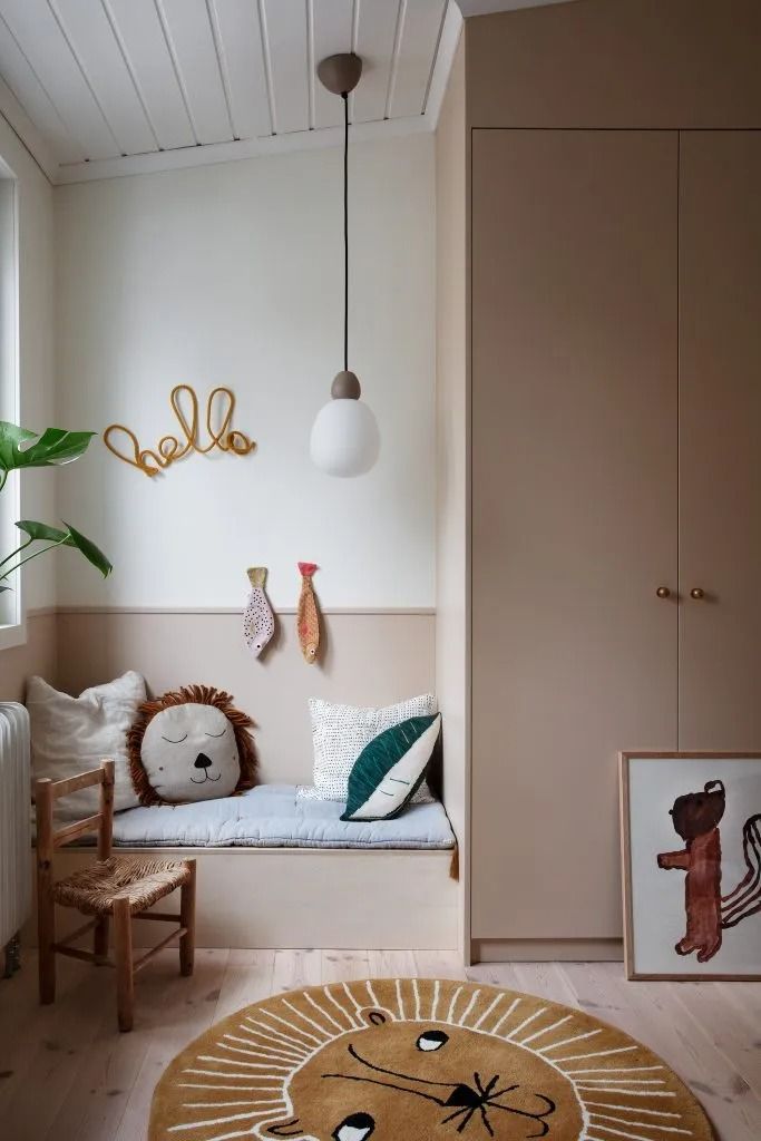 a living room with white walls and wooden floors, including a large round rug on the floor