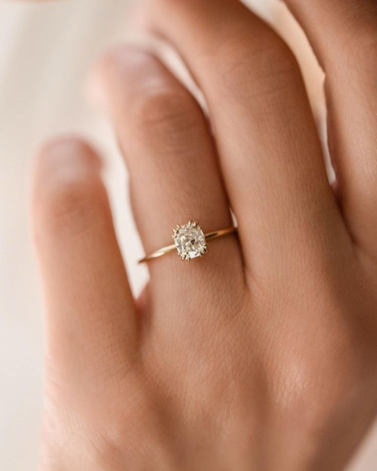 a woman's hand with a diamond ring on it