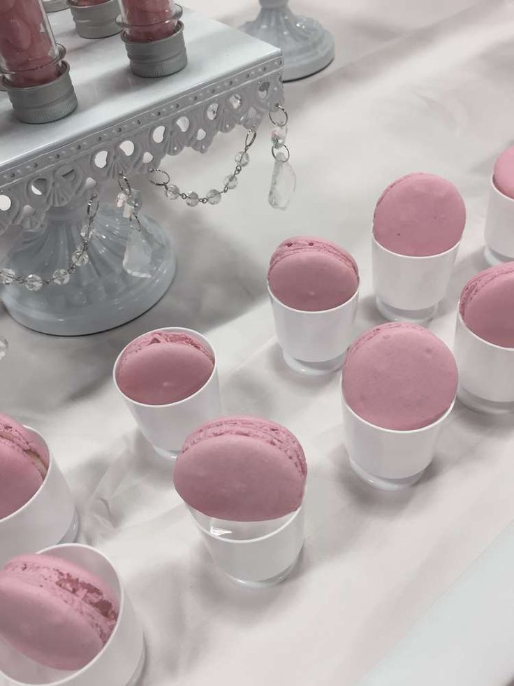 pink and white desserts are arranged on a table