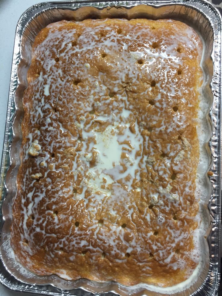 a square cake sitting on top of a pan covered in icing