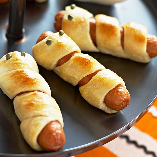 four hot dogs wrapped in bread on a plate