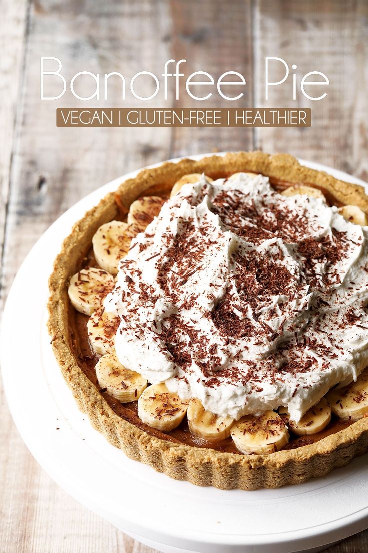 a pie with whipped cream and bananas on top is sitting on a white platter