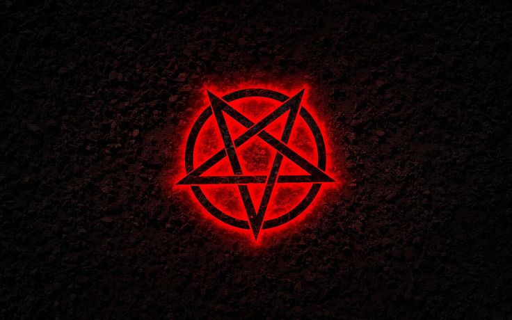 a red pentagramil in the middle of a black background with an orange light