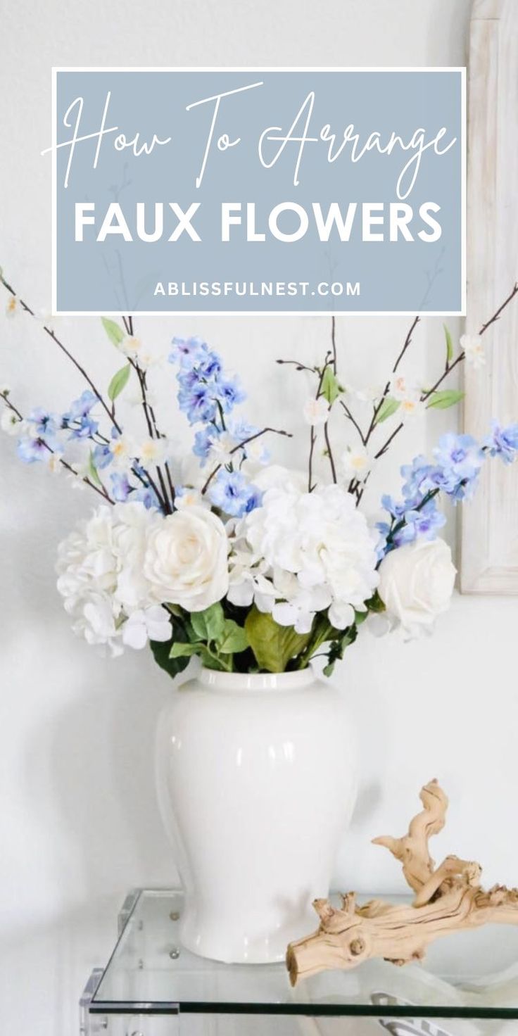 a vase filled with white and blue flowers on top of a glass shelf next to a mirror