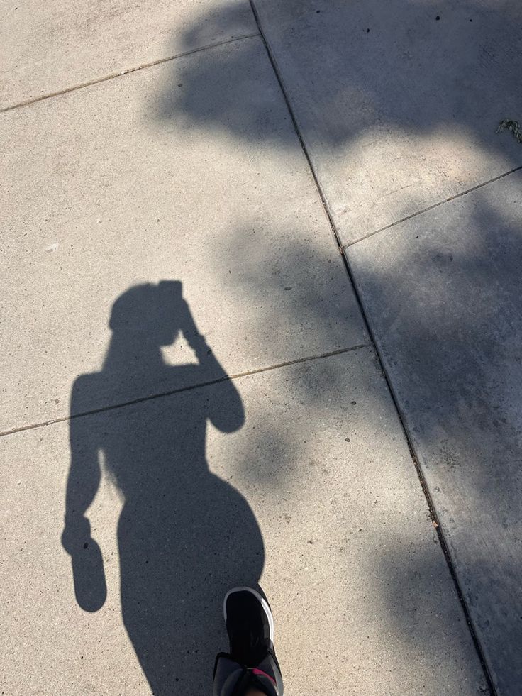 the shadow of a person holding a skateboard