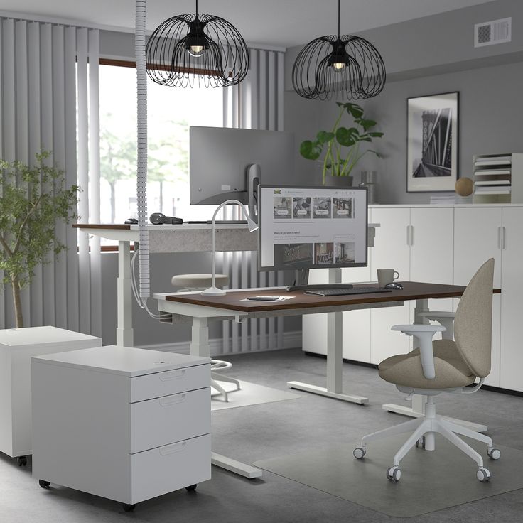 an office with two desks, chairs and a computer monitor on top of it