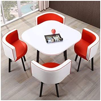 a white table with red chairs and a magazine on the end shelf in front of it