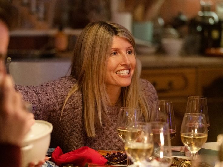 a woman sitting at a table with wine glasses