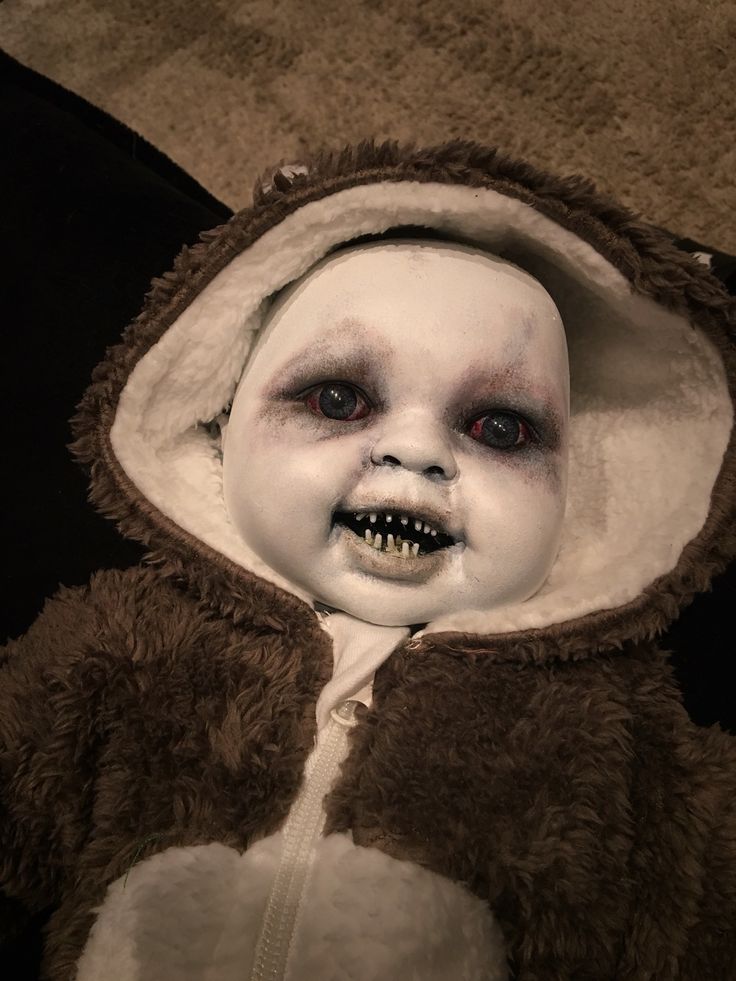 a child in a costume that looks like it has teeth and blood on his face