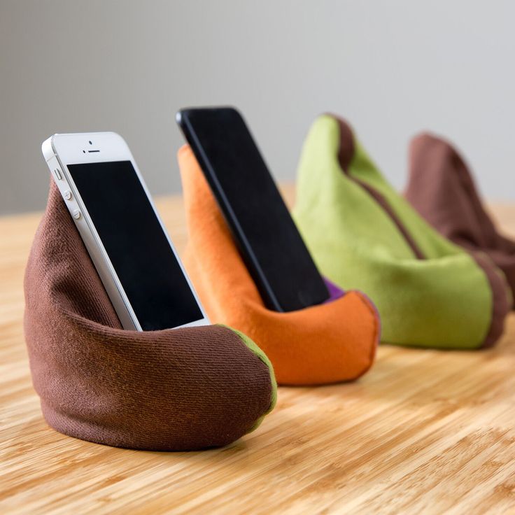 three cell phones are sitting in the shape of shoes on top of a wooden table