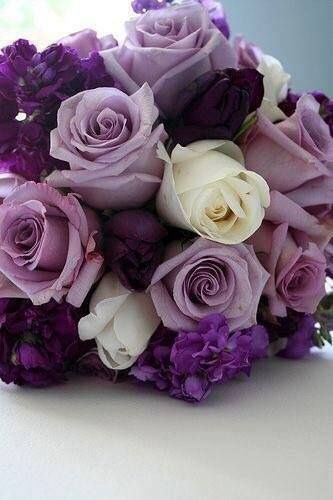 a bouquet of purple and white flowers on a table