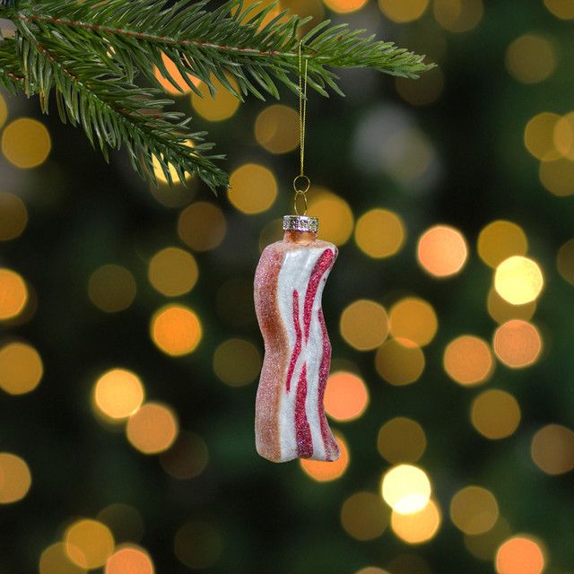 a bacon ornament hanging from a christmas tree with lights in the back ground