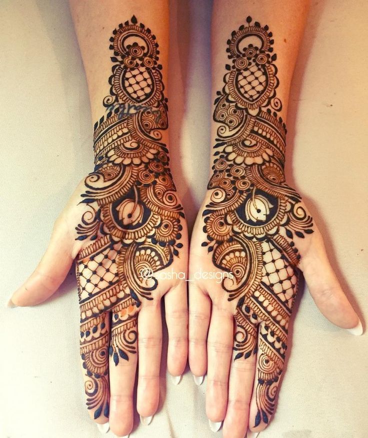 two hands with henna tattoos on them