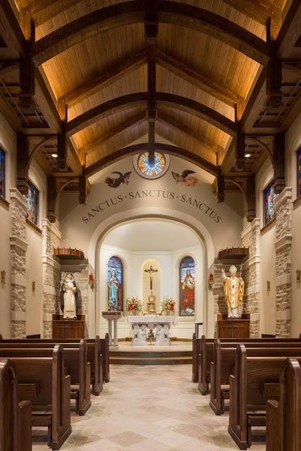 the inside of a church with pews and stained glass windows