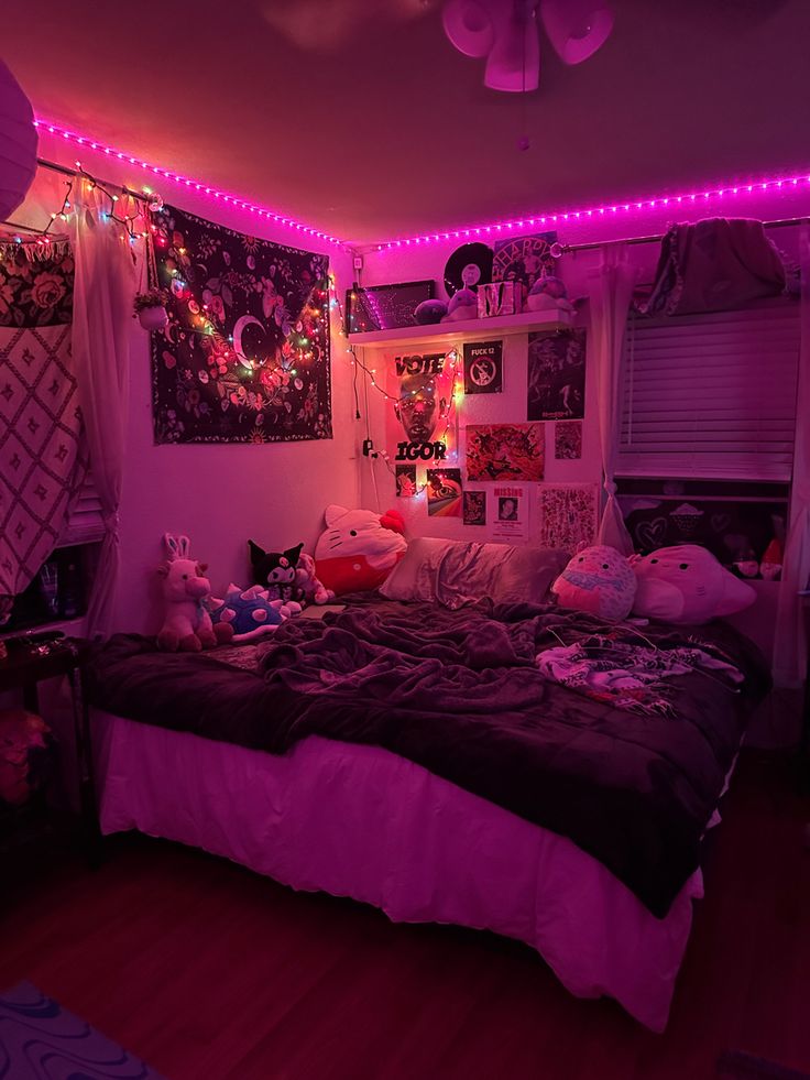 a bedroom with pink lights and stuffed animals on the bed