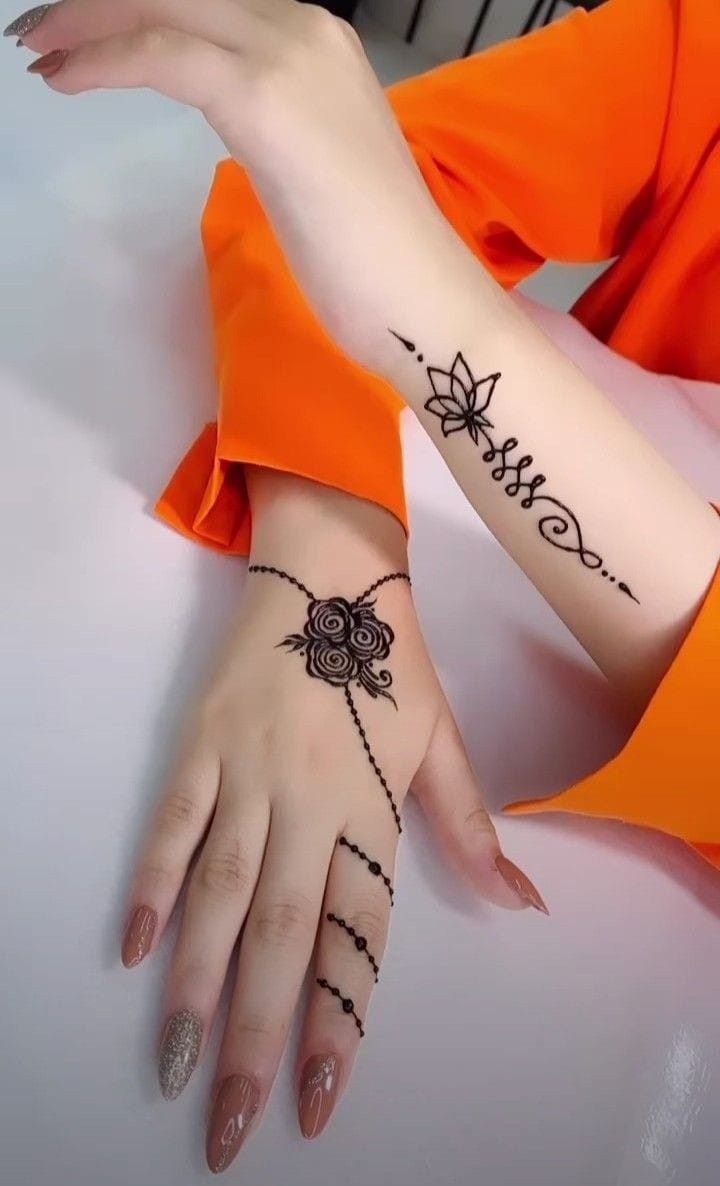 a woman's hands with hendix tattoos on her arm and wrist, both holding onto each other