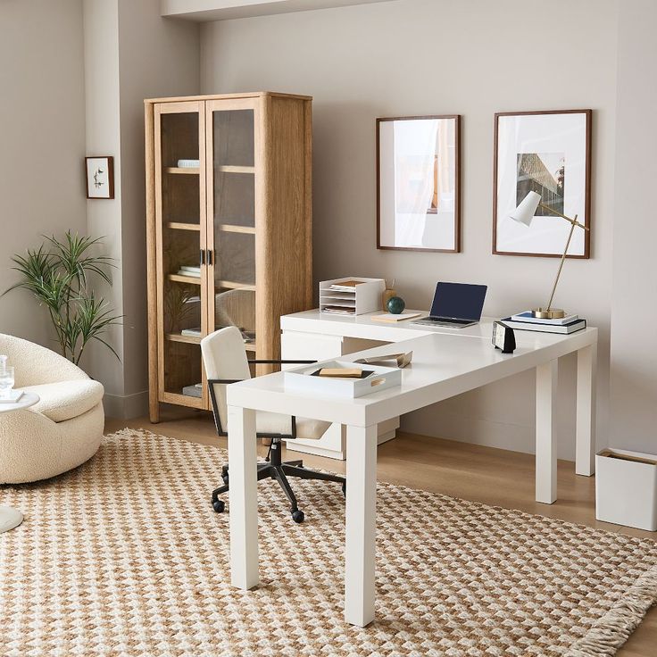 a white desk sitting in the middle of a living room next to a book shelf