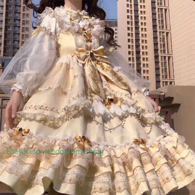 a woman wearing a dress made out of white fabric with gold trims and flowers