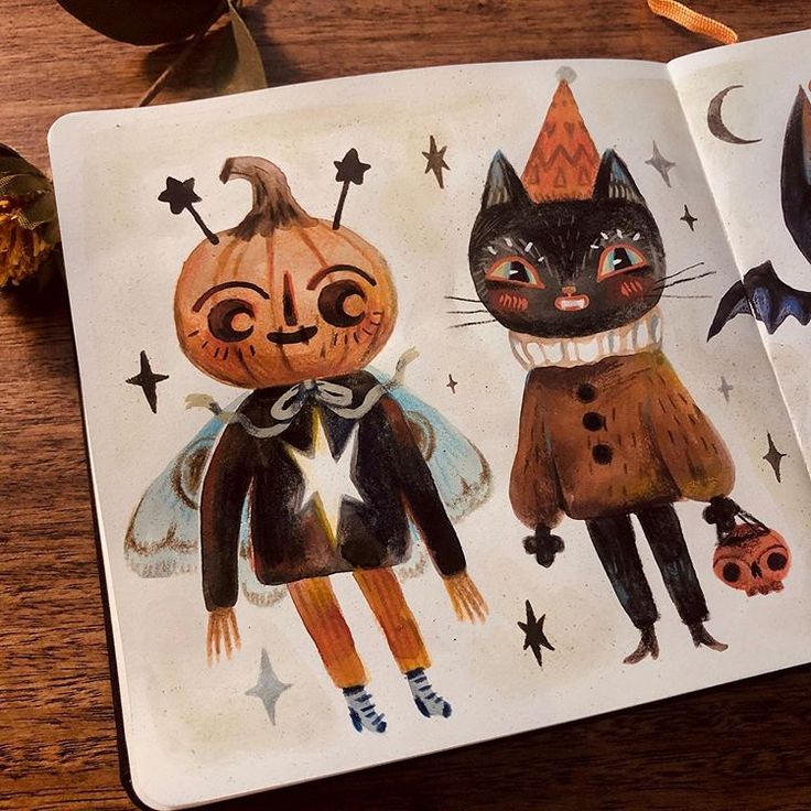 an open children's book with drawings of cats and pumpkins on the pages