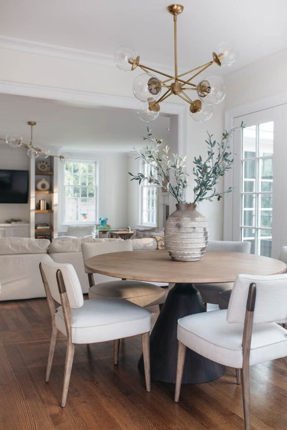 a dining room table with white chairs around it