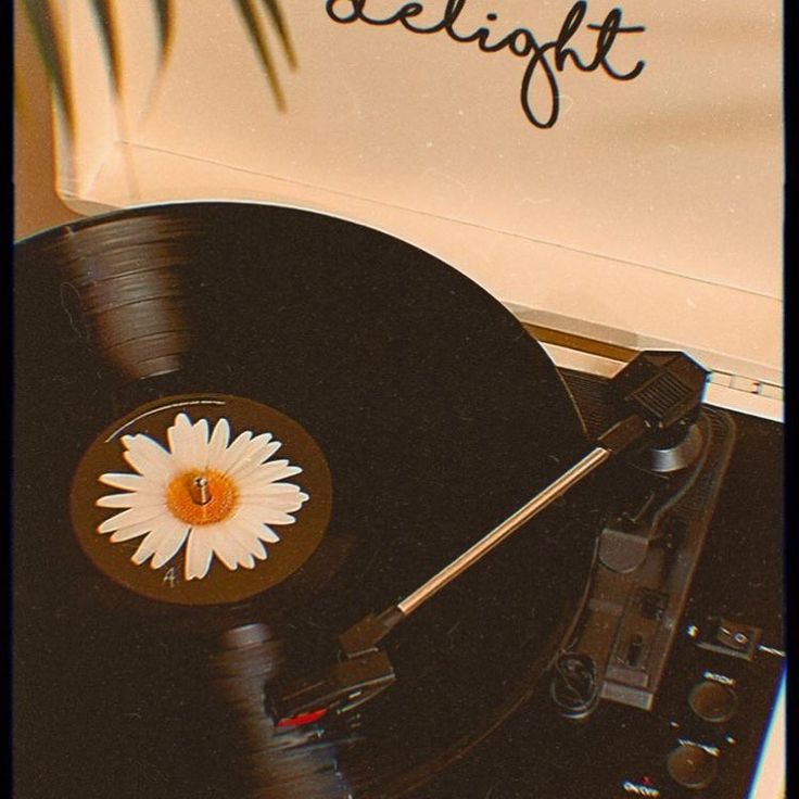 an old record player with a flower on the side and words delight written on it