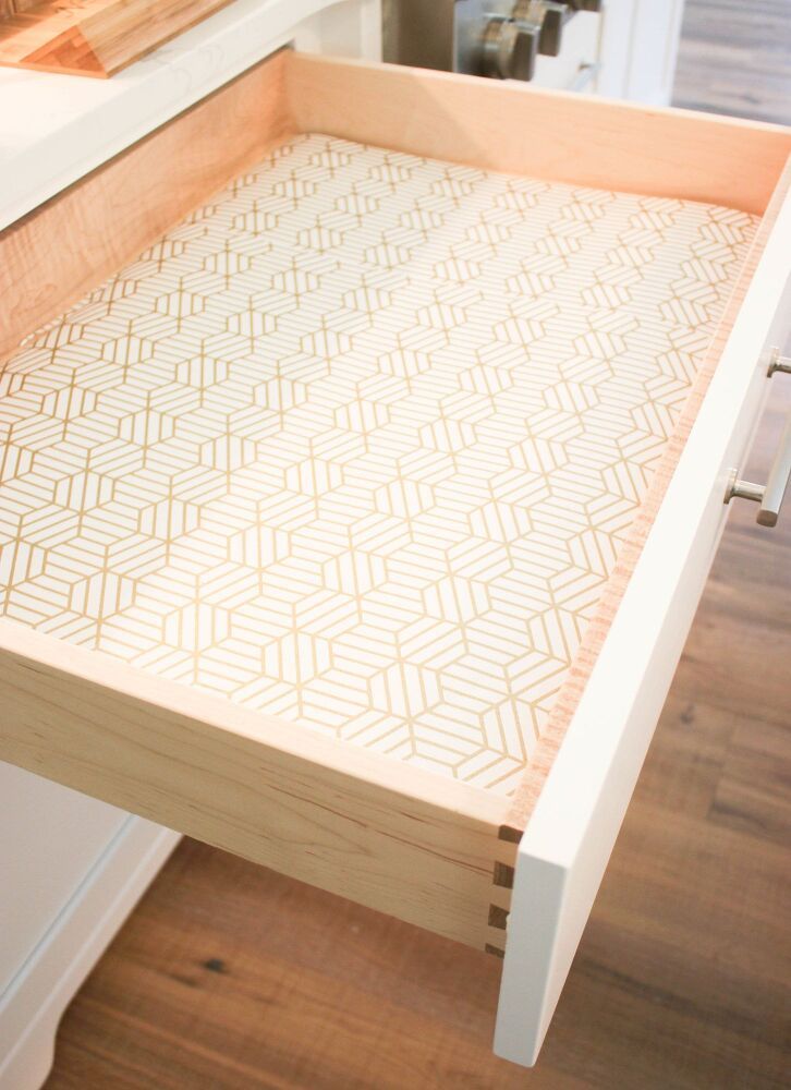 a close up of a wooden tray on a table with drawers in the back ground