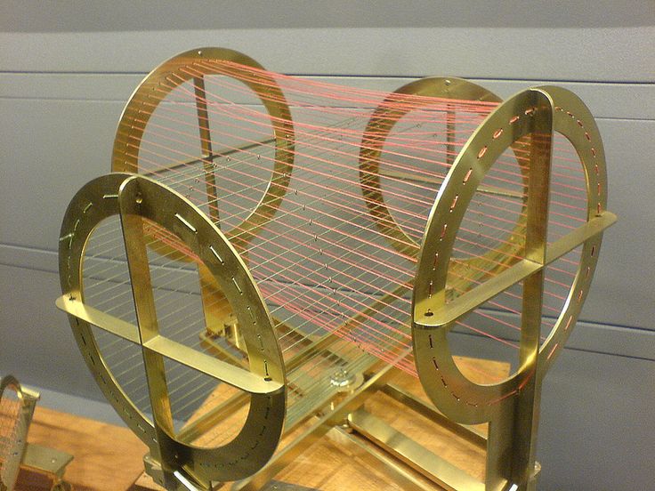 a metal object with two circles on it's sides, sitting on top of a wooden table